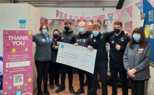 Coaches and members of Core MMA Campbeltown receive their cheque from Co-op staff.