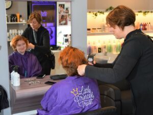 Hair stylist Kerry Dickson takes the shaver to Miranda Bone's head.