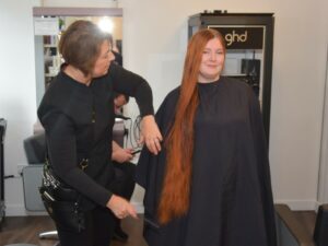 Miranda Bone's long locks being brushed by hair stylist Kerry Dickson before she braved the shave.